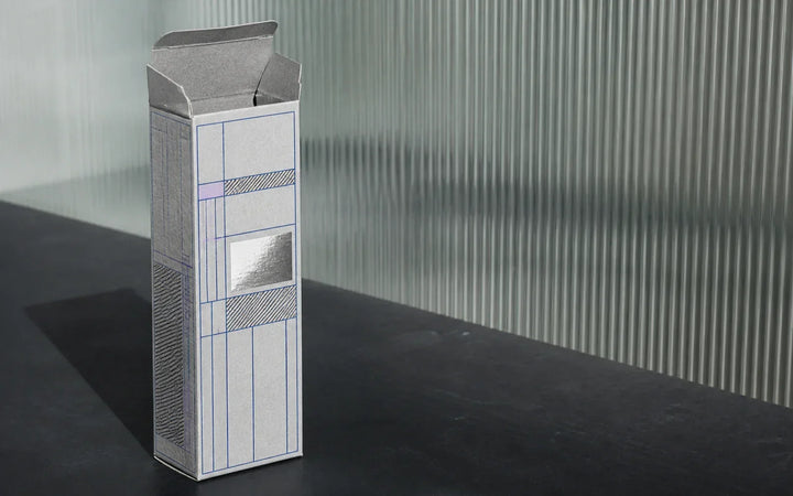 Gray carton with blue grid graphics and a silver panel in a materials lab