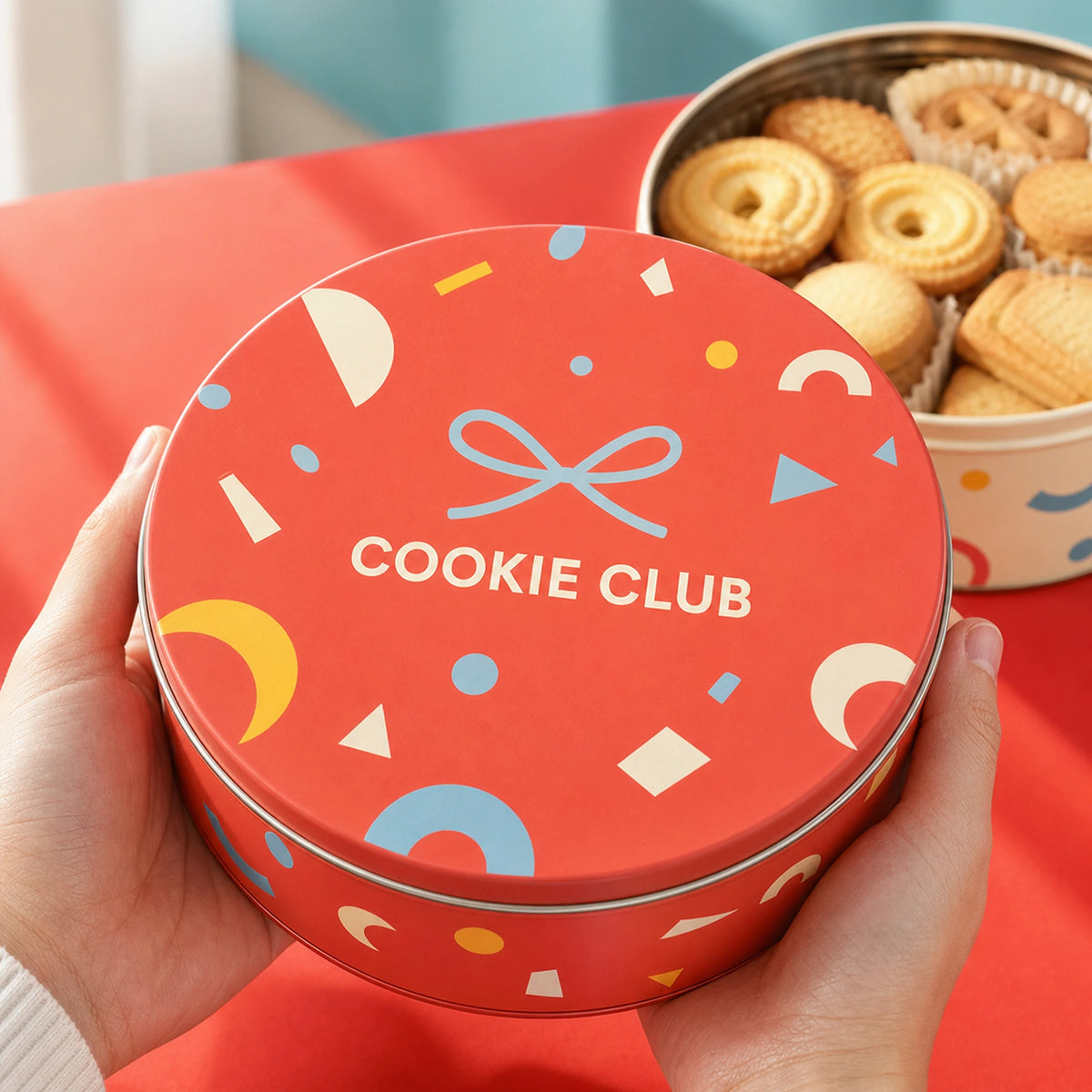 AI-generated concept image of a branded round cookie tin held for gift presentation